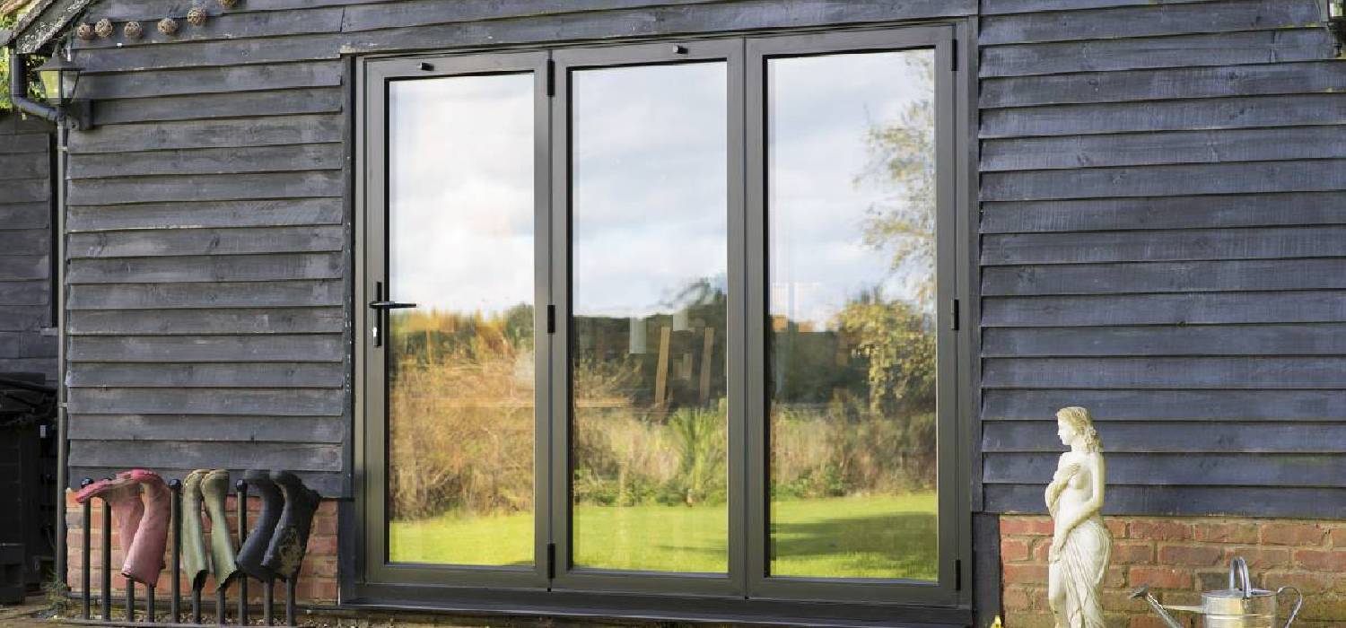 Homeowner cleaning bi-fold doors track for smooth sliding performance